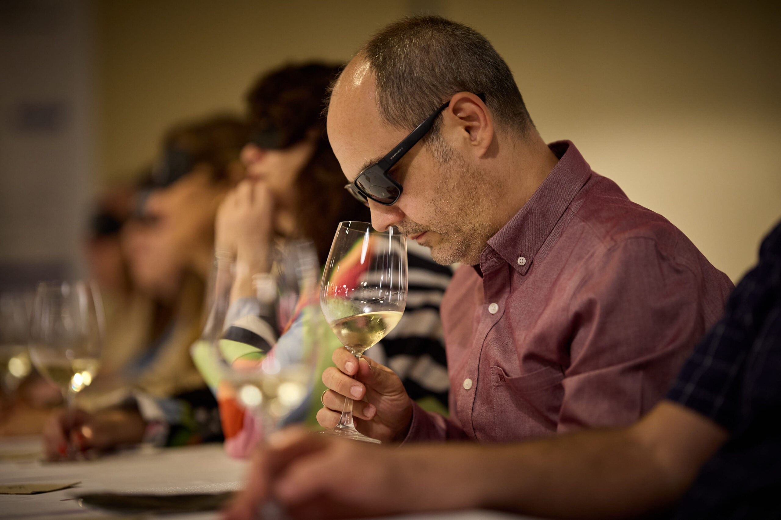 Persona oliendo un vino blanco